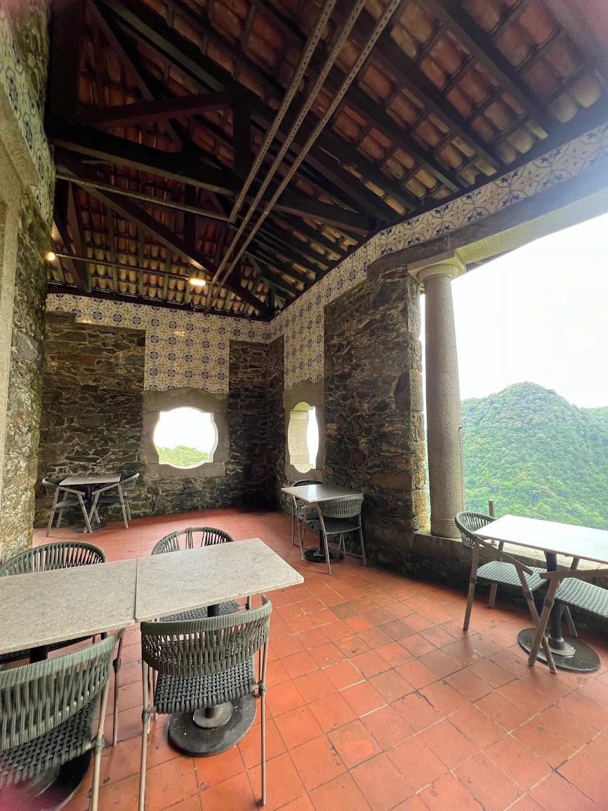 Salão histórico em pedra com azulejos portugueses e vista para a mata